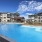 Outdoor swimming pool at Larkspur at Creekside apartments in New Braunfels, TX, featuring lounge chairs and umbrellas.