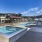 Outdoor swimming pool and hot tub at Larkspur at Creekside apartments in New Braunfels, TX, featuring umbrellas.