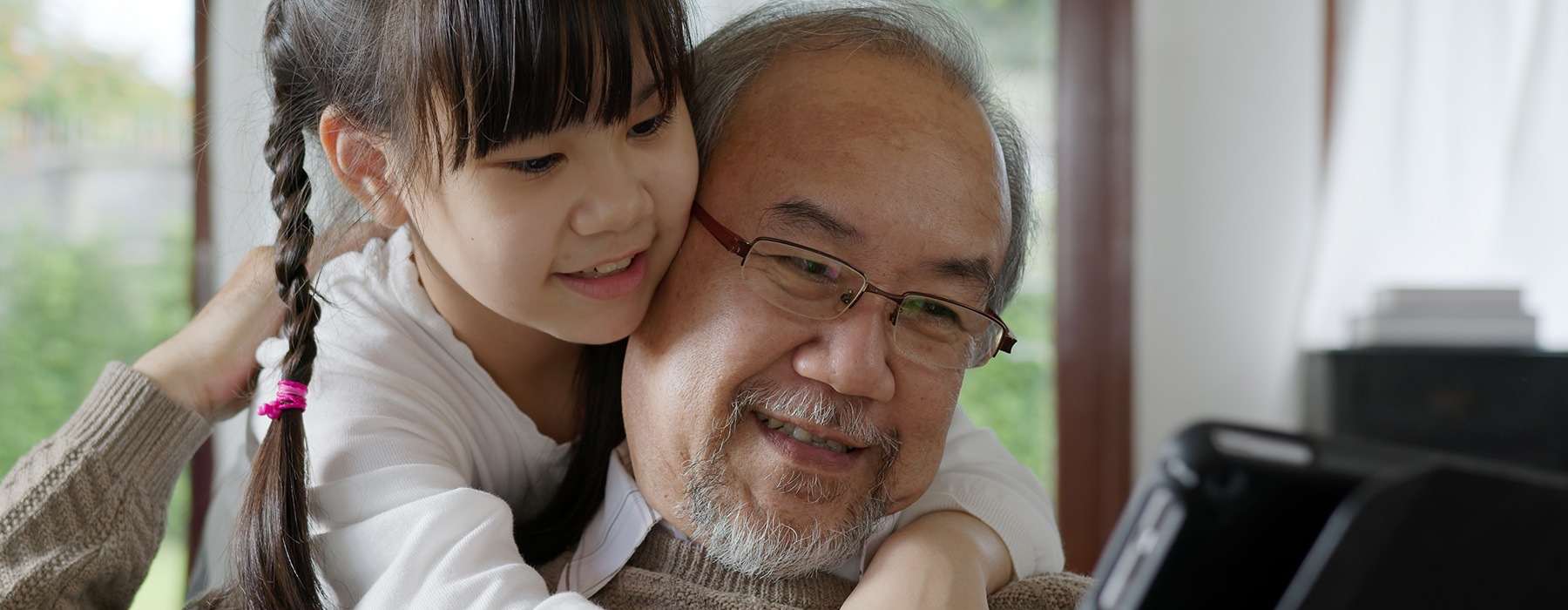 lifestyle image of a older man embracing a girl