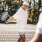 People playing tennis at Larkspur at Creekside apartments in New Braunfels, TX, featuring a sunny court surrounded by trees.